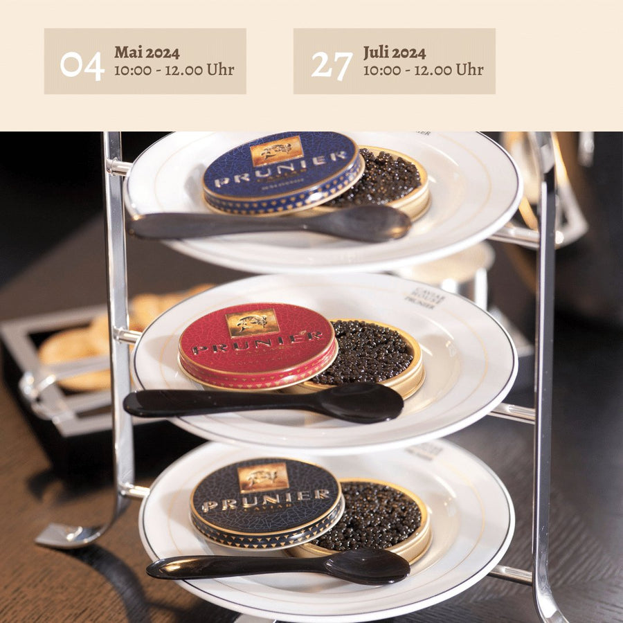 Eine Ausstellung von Dosen mit der Aufschrift „Kaviarfrühstück a la King“-Kaviar auf kleinen Tellern mit Löffeln, präsentiert in einem gestuften Servierständer, mit Werbeveranstaltungsterminen im Mai und Juli 2024 von Johannes King.
