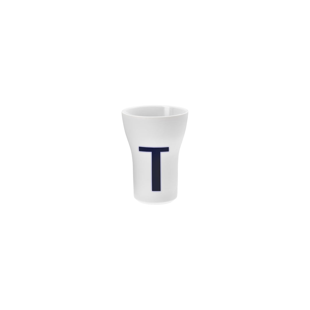 Ein Schnapsglas aus weißem Porzellan mit einem Großbuchstaben T in dunkler Farbe auf der Vorderseite, Teil der Hering Berlin Letter Cups-Kollektion.