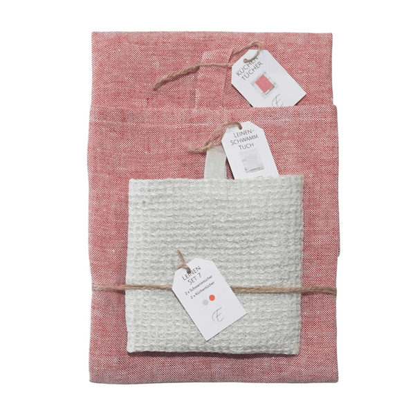 Zwei sauber gefaltete dorothea Waydsch Handtuch-Sets in Weiß und Rot, mit Kordel zusammengebunden und mit Produktinformationen auf weißem Hintergrund versehen.