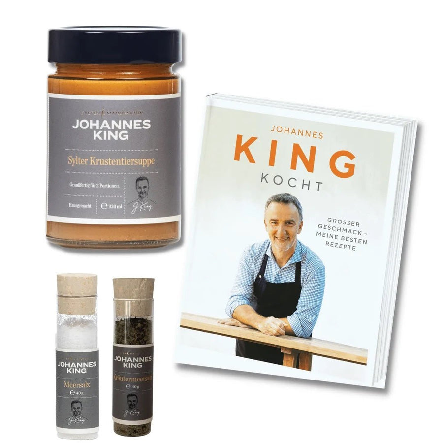 Eine Sammlung kulinarischer Produkte der Sylter Manufaktur und ein Kochbuch mit der Aufschrift „Johannes King“, darunter ein Aufstrichglas, ein Paar Gewürzdosen und das Buch mit dem Titel „Johannes King kocht“.