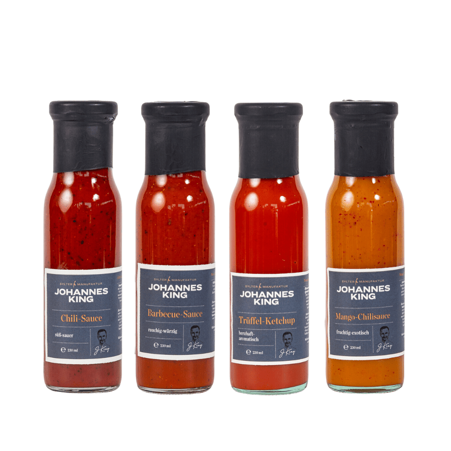 Vier Flaschen Sylter Manufaktur Johannes King-Saucen aufgereiht, darunter Chilisauce, Barbecue-Sauce, Trüffel-Ketchup und Mango-Chili-Sauce, perfekt für jedes Fondue-Saucen-Set.