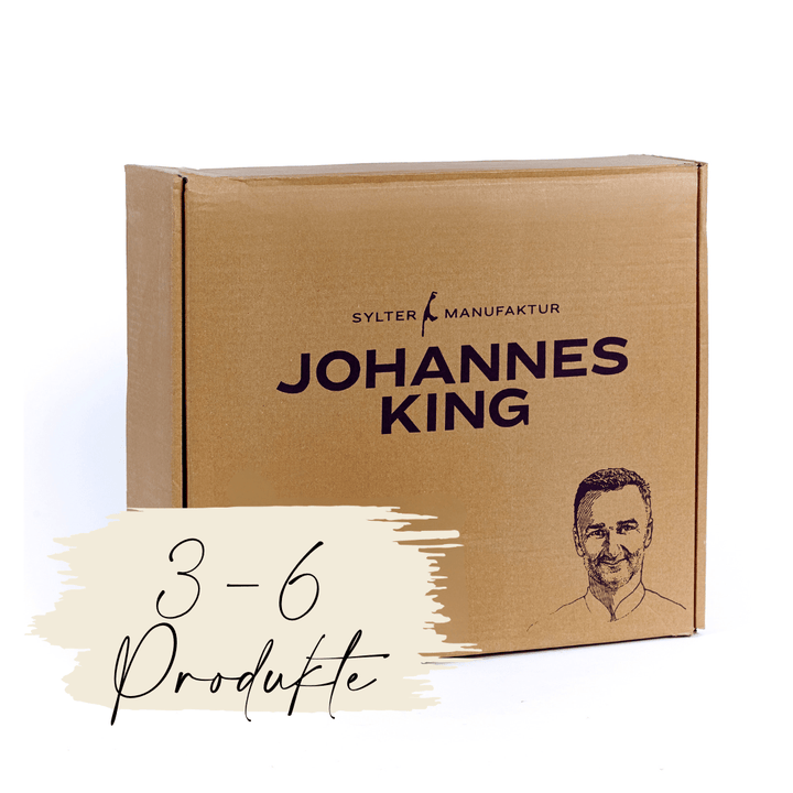 Eine Gourmet-Abo aus der Sylter Manufaktur-Box mit dem Aufdruck „Sylter Manufaktur Johannes König“, daneben eine Abbildung eines Männergesichts und der Text „3-6 produkte“, was darauf hinweist, dass die Box 3 bis 6 Produkte enthält.