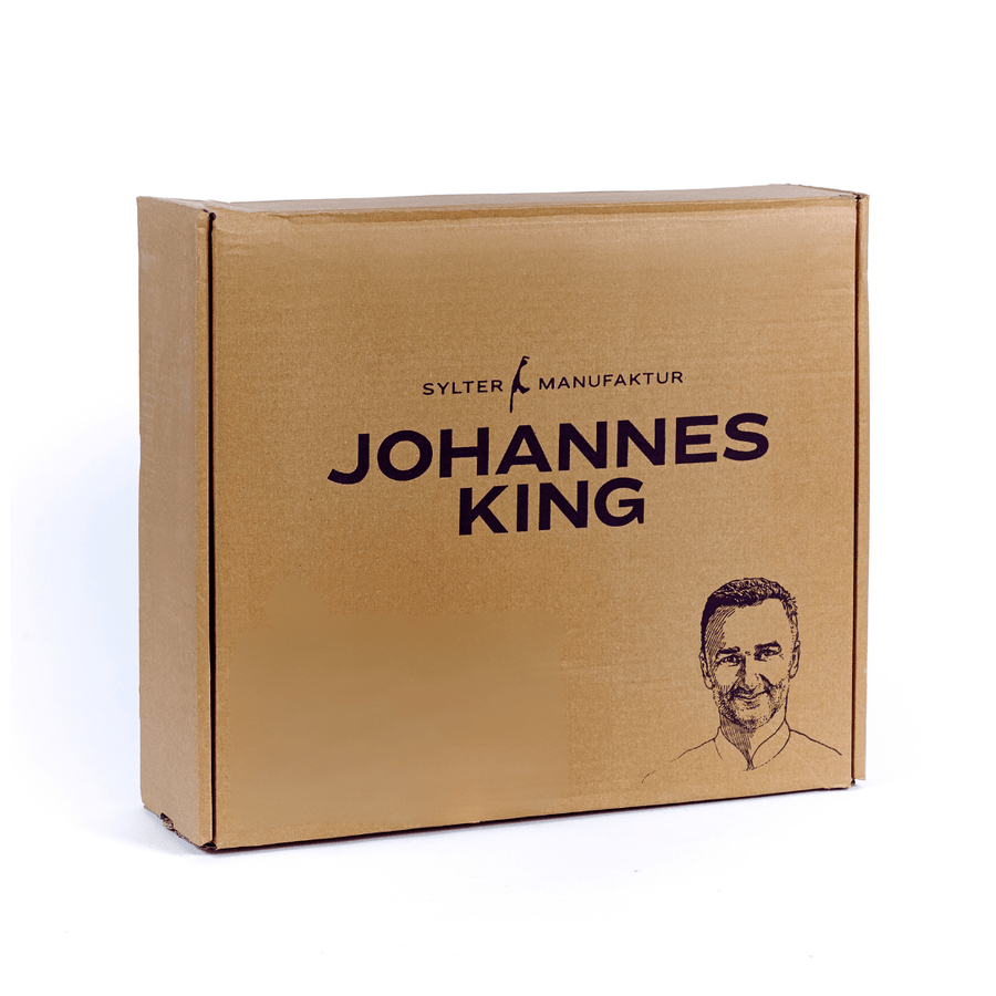 Ein Karton mit Branding, der unter anderem den Namen „Gourmet-Abo aus der Sylter Manufaktur“ und auf der Seite ein Männerportrait der Sylter Manufaktur Johannes King enthält.