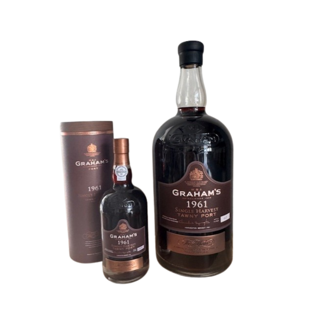 Zwei Flaschen Graham's Single Harvest 1961 (abgefüllt 2025, 0,75 l) sind ausgestellt: eine große und eine normale. Die kleinere Flasche steht neben ihrer zylindrischen Schachtel. Alle sind mit passenden braunen und goldenen Graham's-Etiketten versehen.