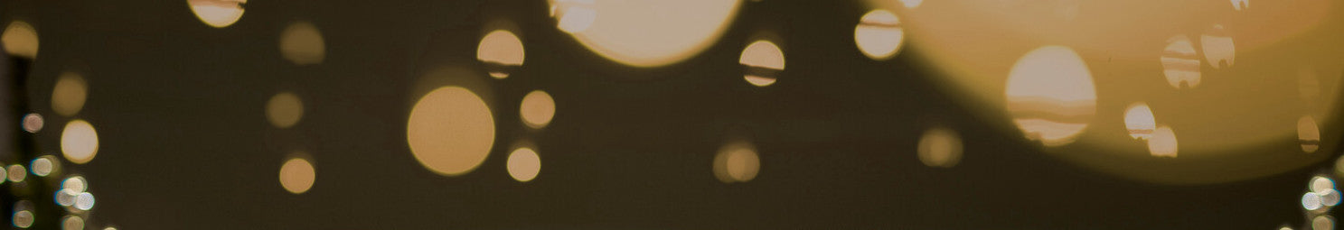 Bokeh-Lichter in warmen Tönen mit einem dunklen Vordergrund, der wahrscheinlich durch unscharfe Lichtquellen entsteht.