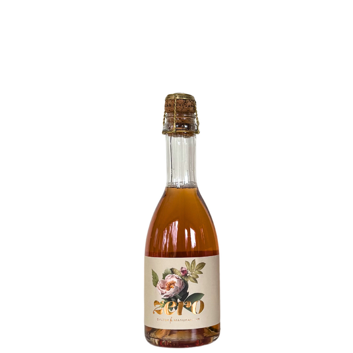 Eine Flasche mit prickelndem Getränk, mit Korken verschlossen und einem Blumenetikett mit dem Wort „Zero“ geschmückt, enthält eine hell bernsteinfarbene Flüssigkeit, die den belebenden Geschmack von Kings Sylter Rosensecco *alkoholfrei* hervorruft und die Essenz der Sylter Heckenrose in jedem Schluck einfängt. Hergestellt von der Sylter Manufaktur Johannes King.