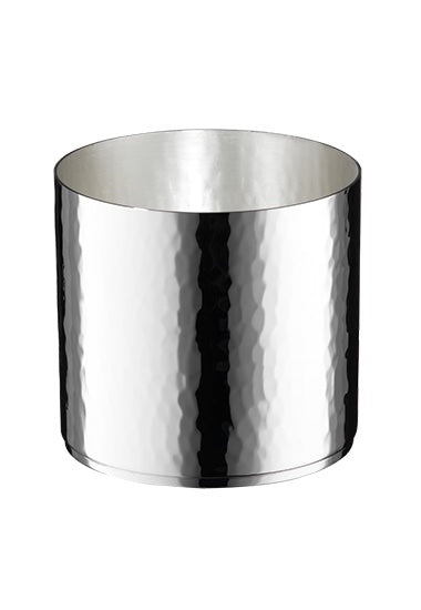 Ein Foto zeigt einen zylindrischen, polierten Metallbehälter mit gehämmerter Struktur. Die spiegelnde Oberfläche des Robbe & Berking Whiskybechers Martelé macht ihn zu einem edlen Blickfang, ohne sichtbare Henkel oder Deckel.