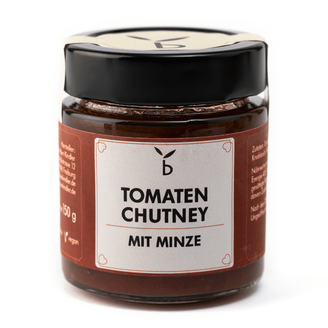 Ein Glas mit schwarzem Deckel, das Benkindler enthält. Tomaten-Chutney mit Minze. Auf dem Etikett steht „Tomaten-Chutney Minze“ und es wiegt 150 g und ist vegan. Dieses Produkt wird aus *frischen Tomaten* hergestellt und verkörpert die handwerkliche Note von Ben Kindler.