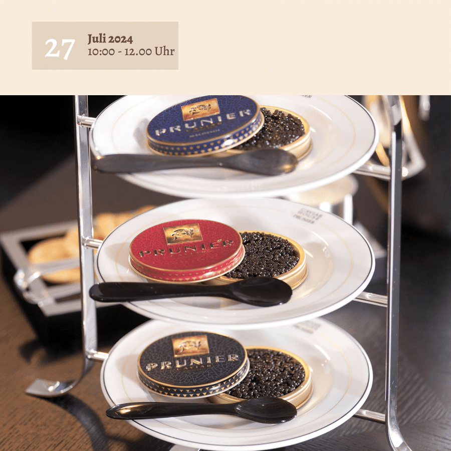 Auf einem dreistöckigen Serviertablett stehen mehrere kleine Teller, auf denen sich jeweils schwarze und rote Dosen „Kaviarfrühstück a la King“ mit der Aufschrift „Johannes King“ befinden. Das Bild suggeriert ein luxuriöses Catering-Ambiente für ein …