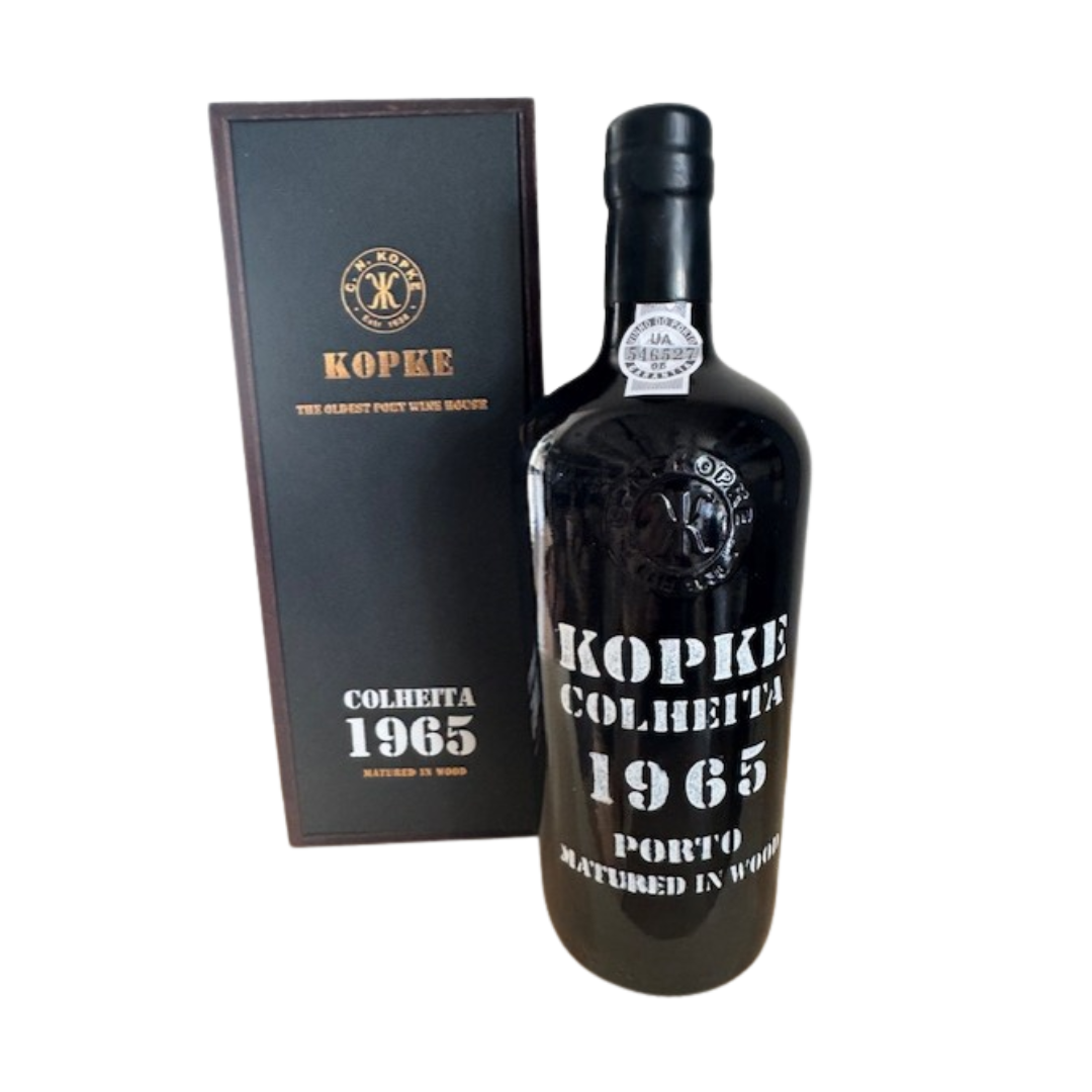 Eine Flasche Kopke White Port Colheita 1965 steht neben der dazugehörigen schwarzen Schachtel, beide mit weißer und goldener Schrift und dem Kopke-Markenlogo versehen.