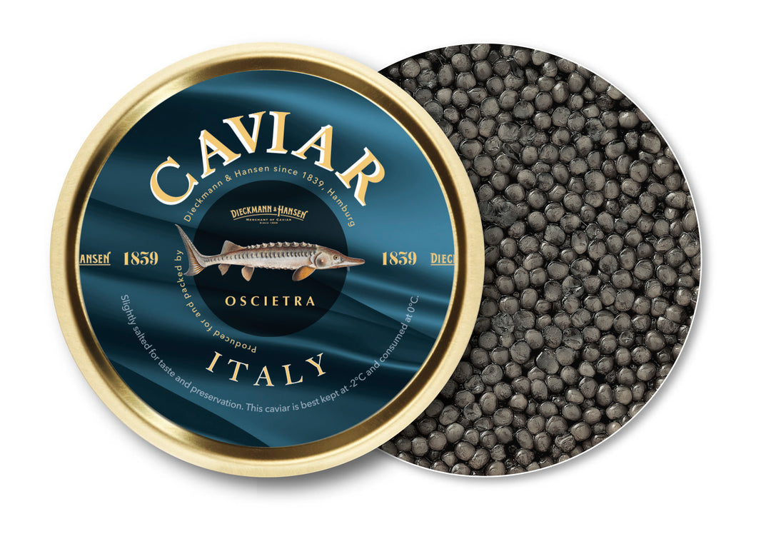 Eine runde Dose Dieckmann & Hansen Kaviar Oscietra Italy ist teilweise geöffnet und zeigt kleine dunkle Kaviareier. Auf dem marineblau-goldenen Etikett ist ein Stör abgebildet.