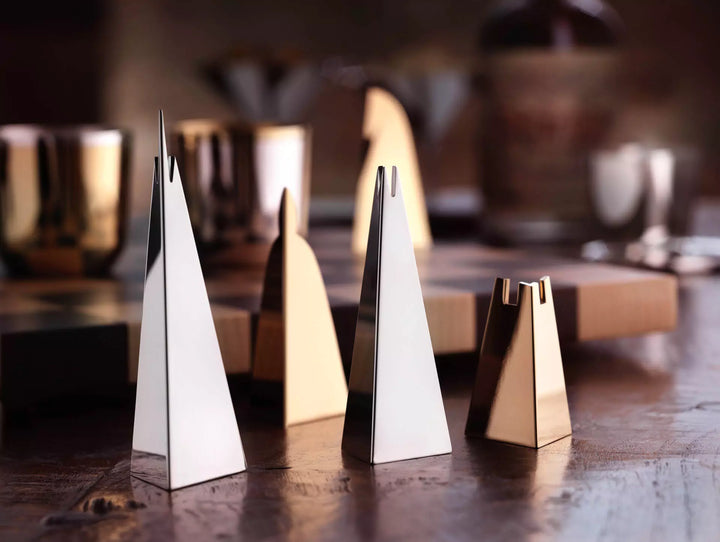 Nahaufnahme reduzierter Schachfiguren aus poliertem Silber und Gold auf dem Holztisch