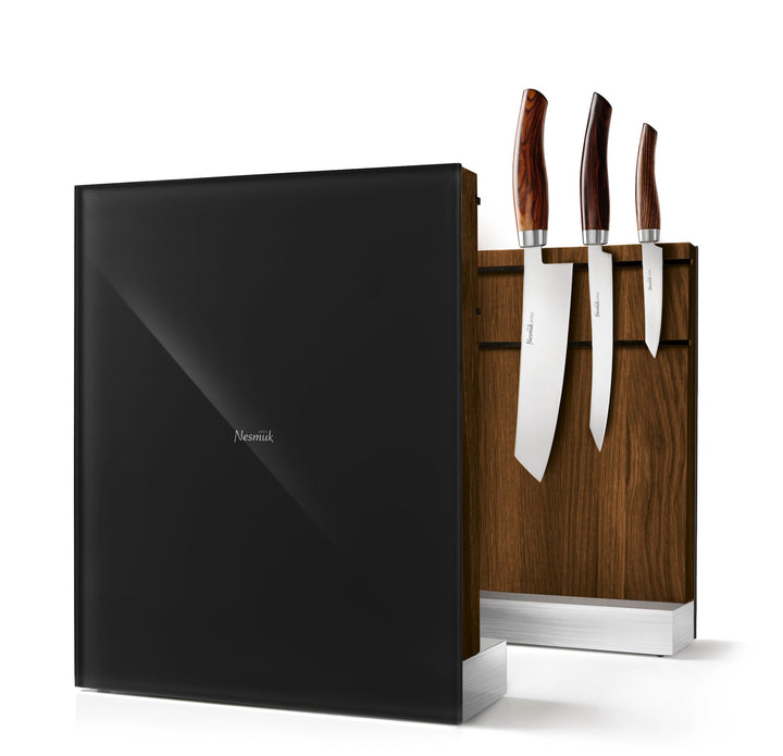 Ein Satz Küchenmesser mit Holzgriffen ist ordentlich in einem dunklen hölzernen Nesmuk-Ständer vor einem weißen Hintergrund platziert.