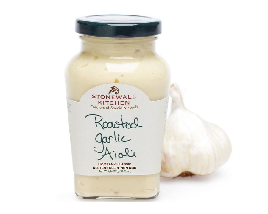 Ein Glas American Heritage Roasted Garlic Aioli mit einer Knoblauchknolle daneben.