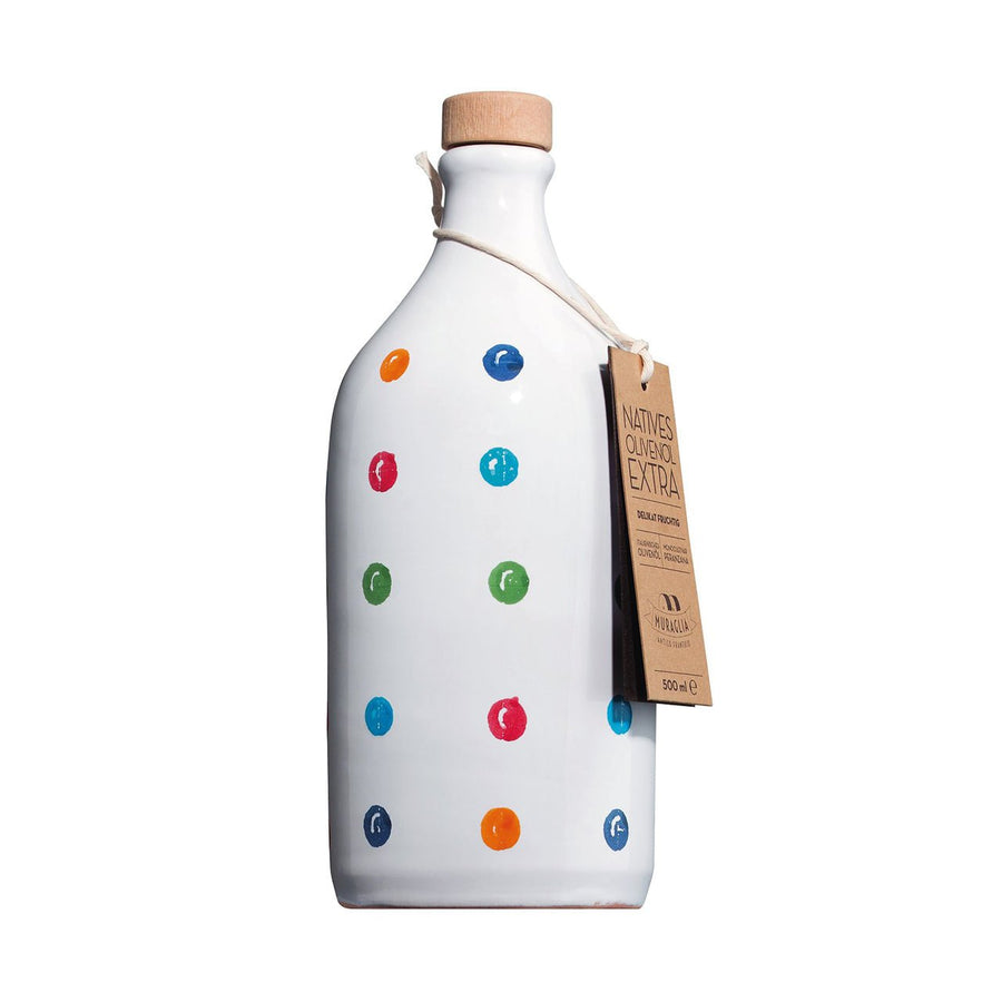 Eine weiße Keramikflasche mit bunten Punkten und einem Korkstopfen, beschriftet mit einem Schild mit der Aufschrift „Muraglia Olivenöl in Tonflasche *gepunktet* extra vergine“, vor weißem Hintergrund.