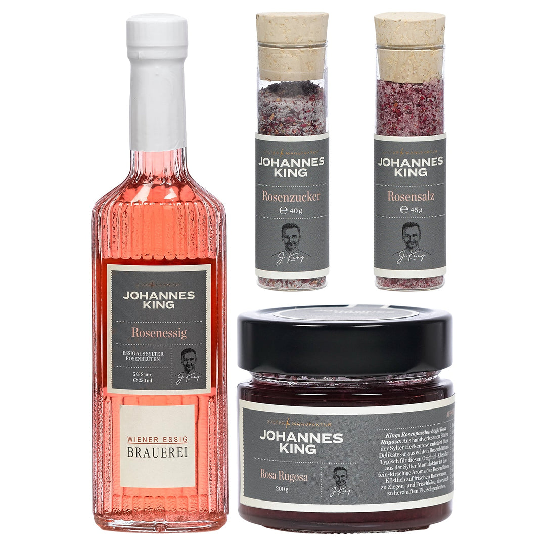 Eine Kollektion von Rosiges Vergnügen-Produkten der Sylter Manufaktur Johannes King, darunter eine Flasche Rosenessig sowie Gläser mit Rosenzucker und Rosensalz.