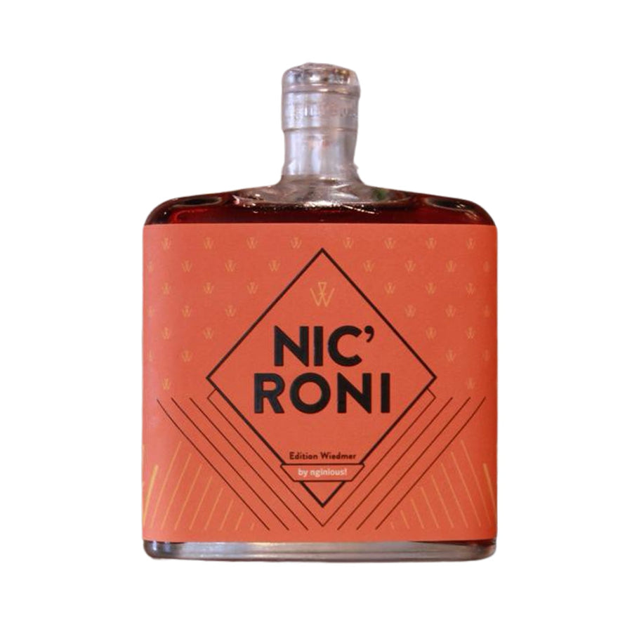 Eine transparente Glasflasche, gefüllt mit einer rötlich-braunen Flüssigkeit, mit der Aufschrift „Nicroni Cocktail, NIC'RONI Edition by Eckert Fine Dining“ vor weißem Hintergrund.