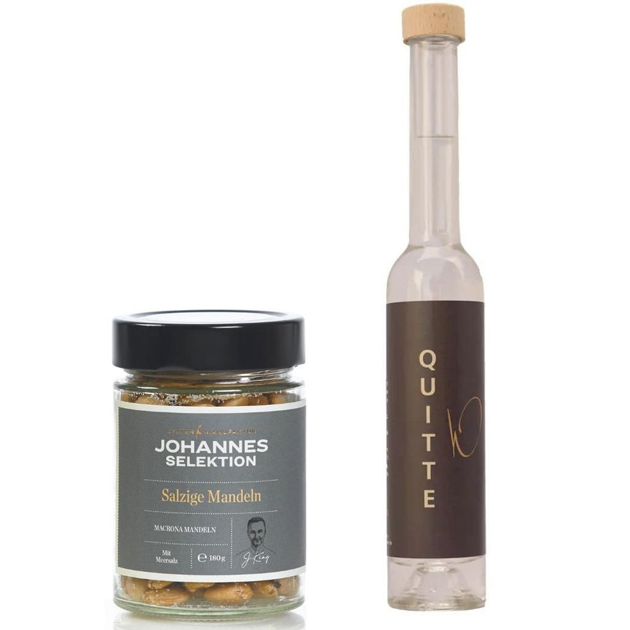 Ein Glas „Salzige Mandeln der Sylter Manufaktur Johannes König“ neben einer Flasche Likör „Cheers Quitte, bitte“.