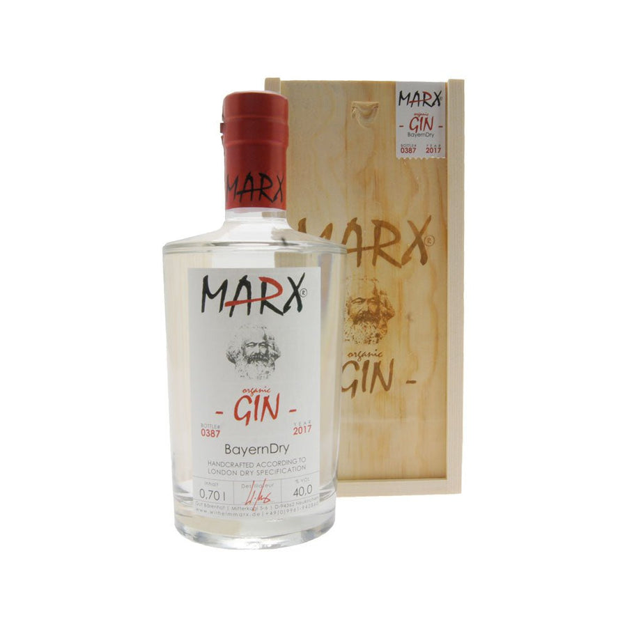 Eine Klarglasflasche GIN BAYERN DRY von Wilhelm Marx mit rotem Verschluss, neben der Holzverpackung, vor weißem Hintergrund.