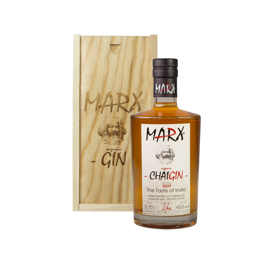 Eine Flasche Marx - Chai Gin von Wilhelm Marx neben der Holzverpackung mit deutlich sichtbarem Branding.