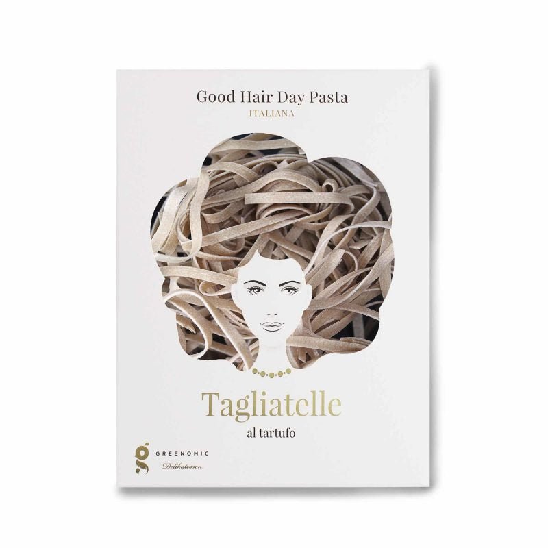 Eine Packung „Good Hair Day Pasta – Tagliatelle al tartufo“ von Greenomic mit einer Illustration einer Frau, deren Haare durch ein Bild von Tagliatelle al tartufo ersetzt wurden, das die darstellt.