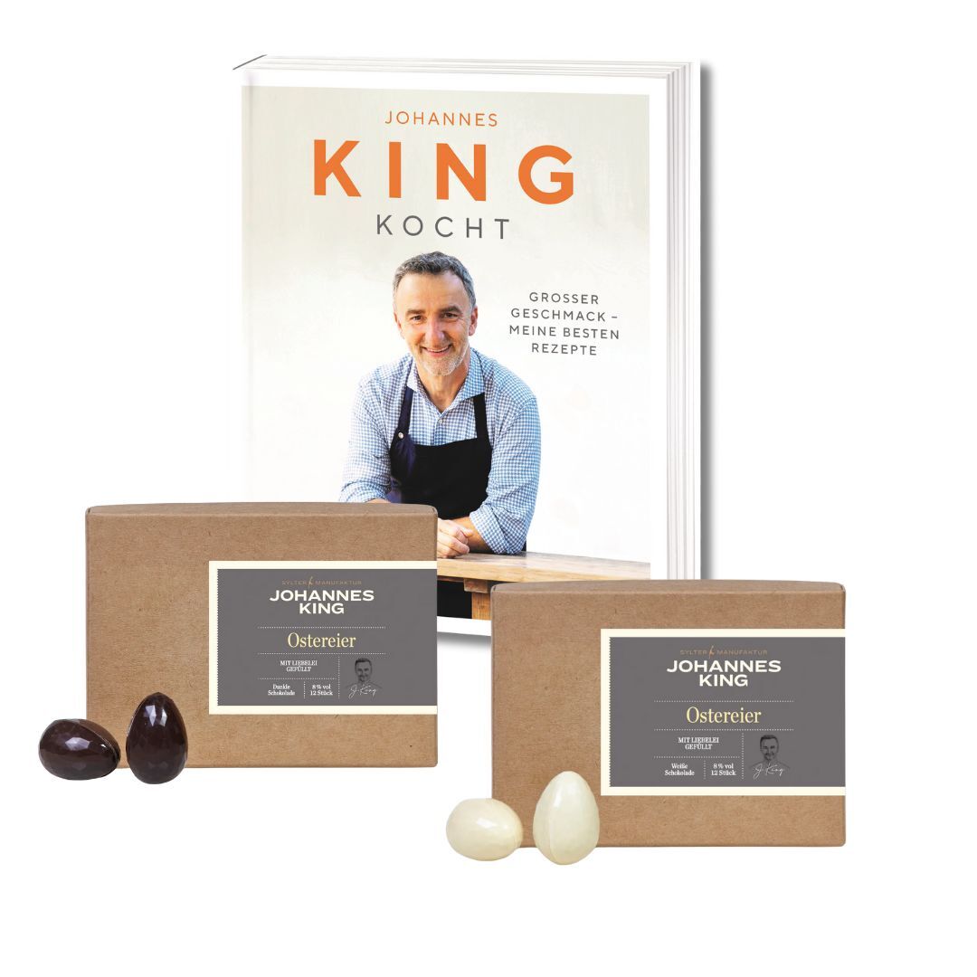 Dieses Bild zeigt ein Kochbuch-Nest der Sylter Manufaktur Johannes King mit dem Titel „Johannes King Kocht“ mit einem Bild des Mannes selbst auf dem Cover, vermutlich Johannes King, sowie zwei verpackten Lebensmitteln, die sein Bild tragen.