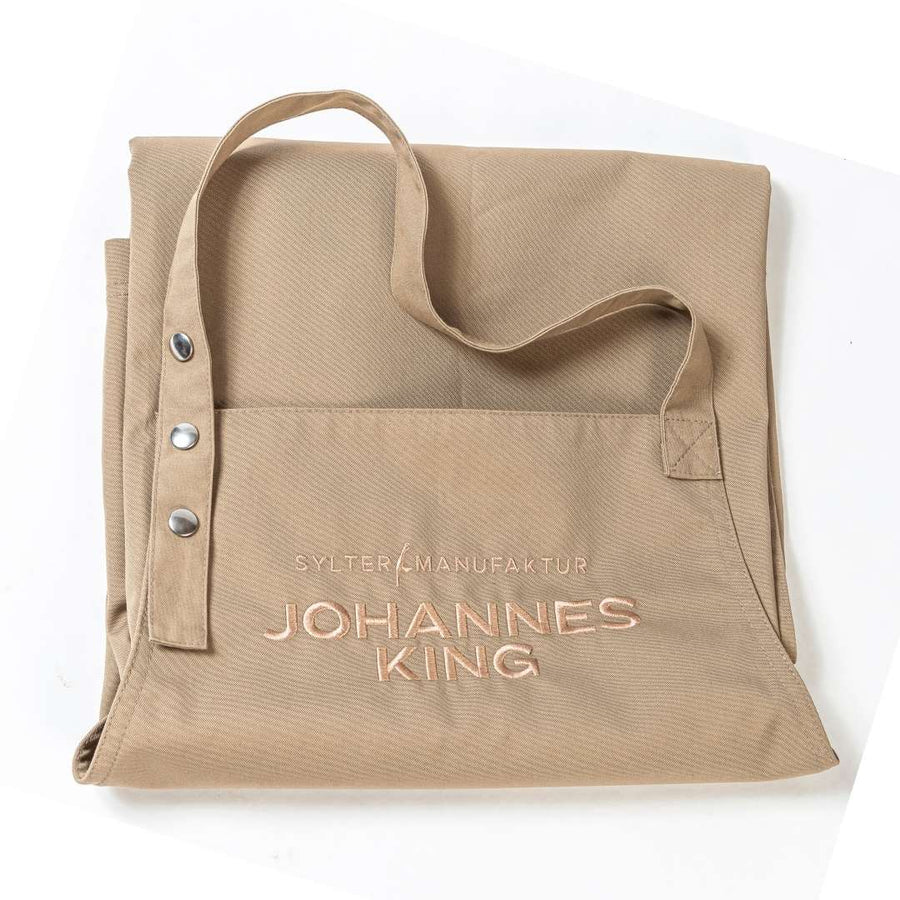 Beiger Stoffbeutel mit dem Text „Sylter Manufaktur Johannes King“ auf der Vorderseite, mit zwei Knöpfen verschließbar und aus nachhaltiger Produktion gefertigt.