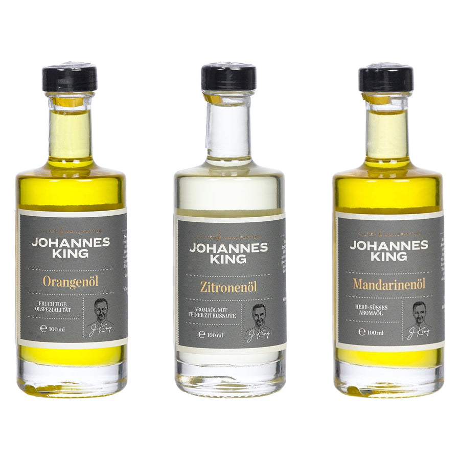 Drei Flaschen Sylter Manufaktur Johannes King Aromaöl-Trio *Citrusfrüchte*, mit Geschmacksrichtungen gekennzeichnet als Orangen-, Zitronen- und Mandarinenöl.