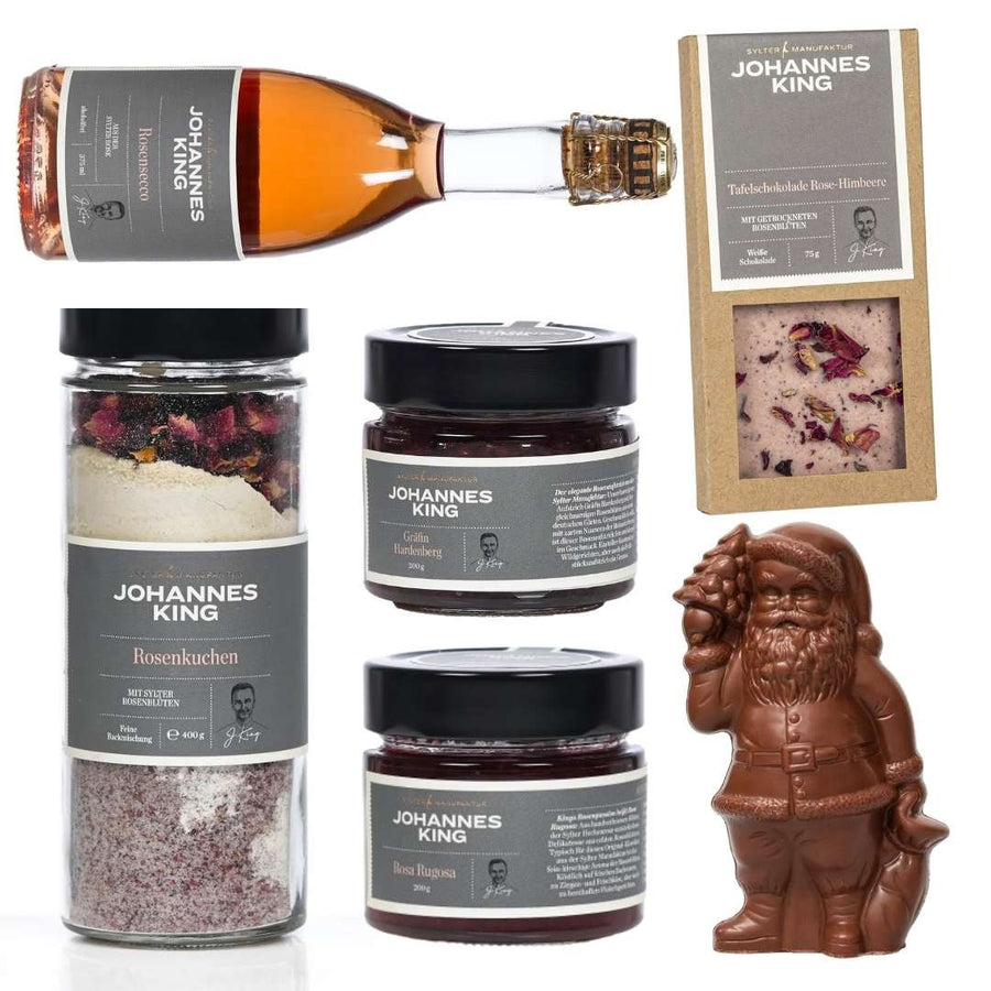 Eine Kollektion von Sylter Manufaktur gebrandeten Gourmet-Lebensmitteln und feiner Schokolade zu Weihnachten, einschließlich Flaschen Roséwein, Gl
