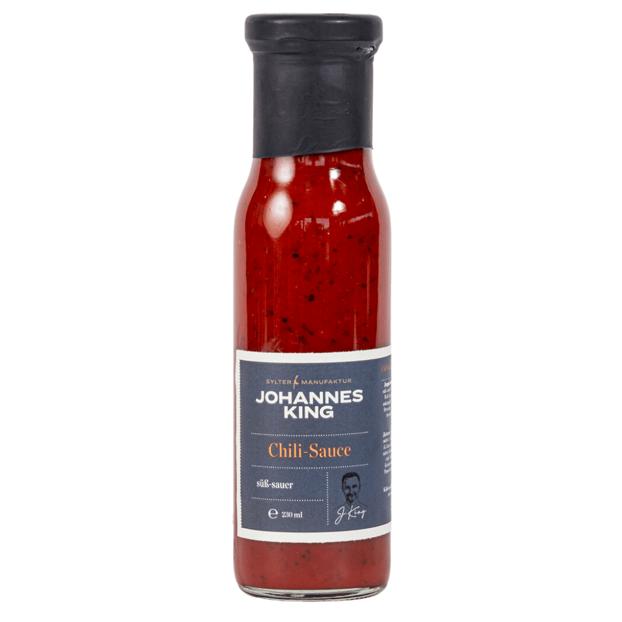 Eine Flasche Sylter Manufaktur süße Chili-Sauce mit dunklem Etikett, enthält 200 Milliliter rote, gesprenkelte Sauce.