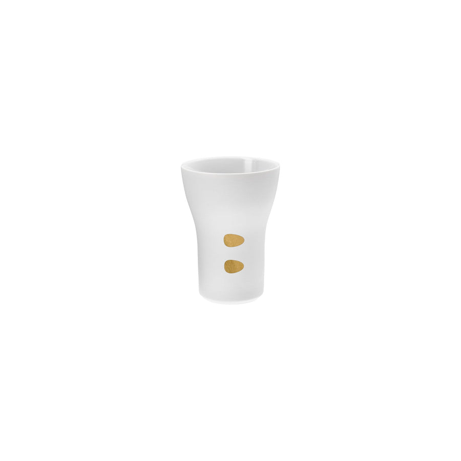 Ein Schnapsglas aus weißer Keramik von Hering Berlin mit zwei goldenen Punkten.