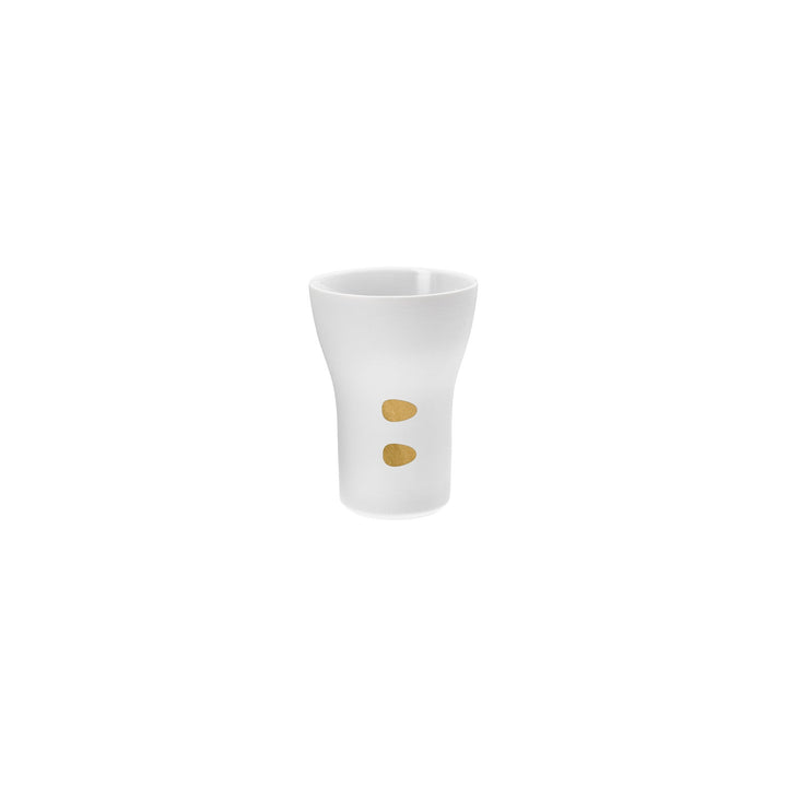Ein Schnapsglas aus weißer Keramik von Hering Berlin mit zwei goldenen Punkten.