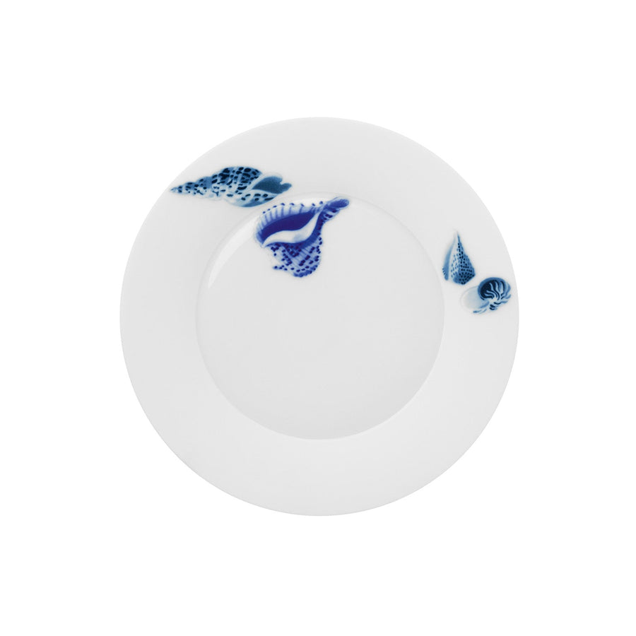 Ein weißer Keramikteller mit blauen Muschel- und Meeresmotiven am Rand vom Hering Berlin Frühstücksteller Ocean Muscheln.