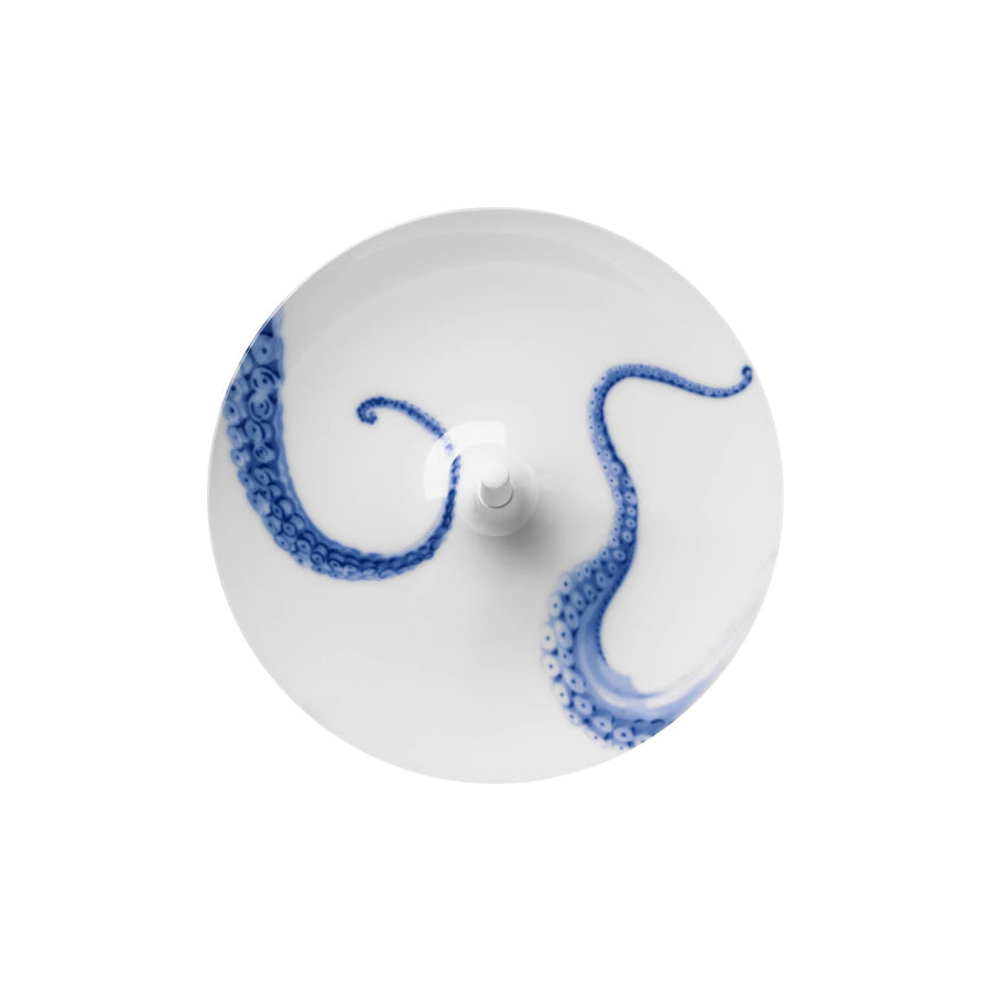 Ein weißer Teller von Hering Berlin mit einem dekorativen blauen Oktopus-Tentakel-Design auf der Oberfläche.