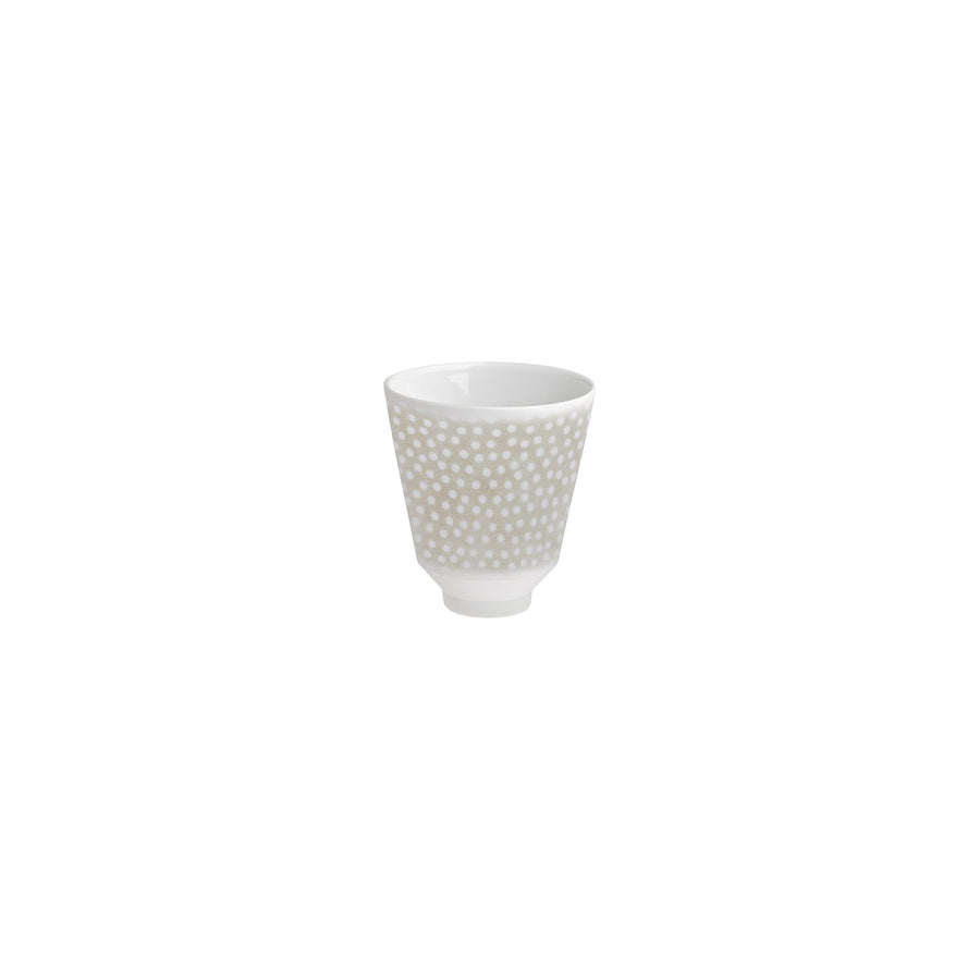Eine leere weiße Hering Berlin Becher Illusion Tasse mit gepunktetem Muster, isoliert auf weißem Hintergrund.