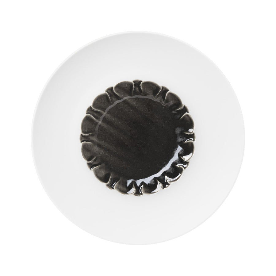 Ein schwarzer Hering Berlin Coupeteller, tief mit Facette Evolution - Obsidian-Pasta auf einem weißen Teller.