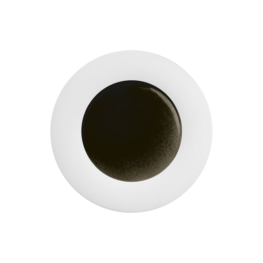 Kreisförmiges Objekt mit schwarzem Zentrum, umgeben von einem weißen Ring auf weißem Hintergrund. Hering Berlin Frühstücksteller Obsidian.