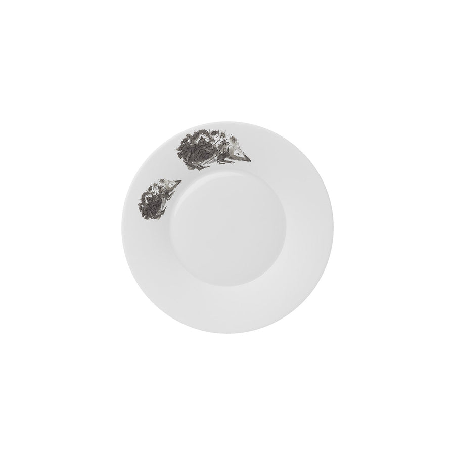 Ein weißer runder Teller mit zwei kleinen, zerknitterten Stücken Hering Berlin Kuchen- und Brotteller Piqueur 2 Igel auf der Oberfläche.