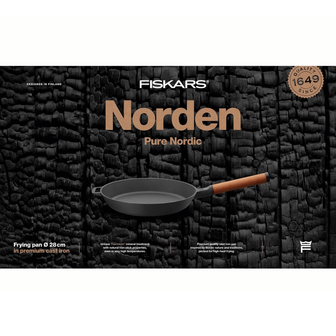 Eine Norden Bratpfanne der Fiskars Group, 28 cm Bratpfanne aus hochwertigem Gusseisen, entworfen in Finnland, mit Holzgriff, vor einem schwarzen strukturierten Hintergrund mit dem Markenlogo und dem Slogan „Pure Nordic“ darüber abgebildet.