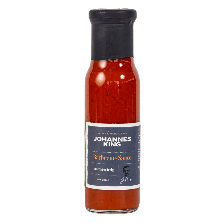 Eine Flasche Sylter Manufaktur-Barbecue-Sauce mit einem Etikett, das darauf hinweist, dass sie rauchig und würzig ist, angereichert mit Mango-Chili-Sauce.