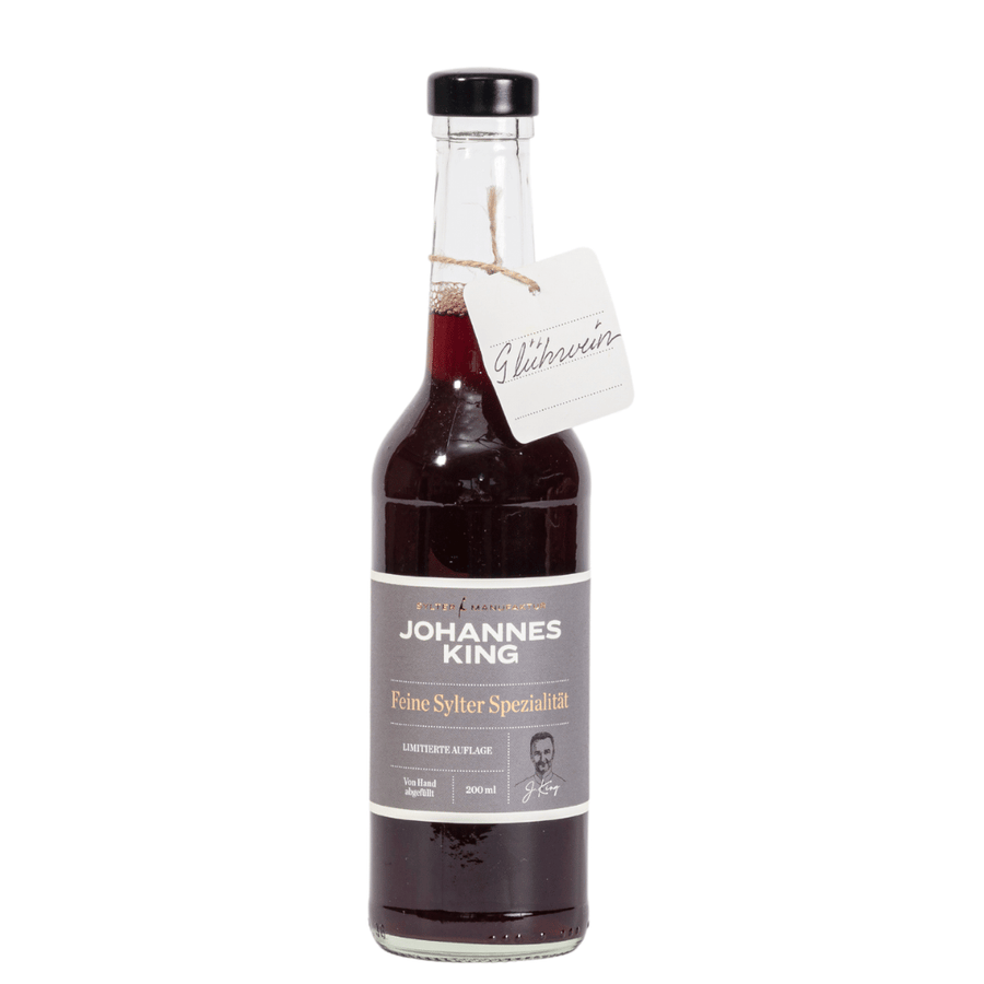 Eine Flasche Sirup der Marke Sylter Manufaktur „Glühwein aus der Sylter Manufaktur“ mit Etikett und angehängtem Schild mit dem Produktnamen.