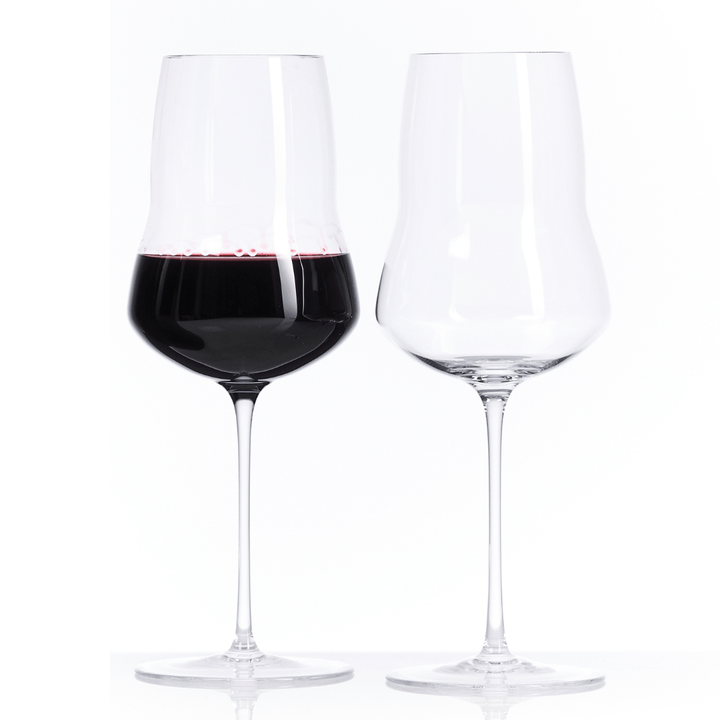 Zwei Hering Berlin Portweingläser vor weißem Hintergrund, eines mit Rotwein gefüllt und das andere leer.