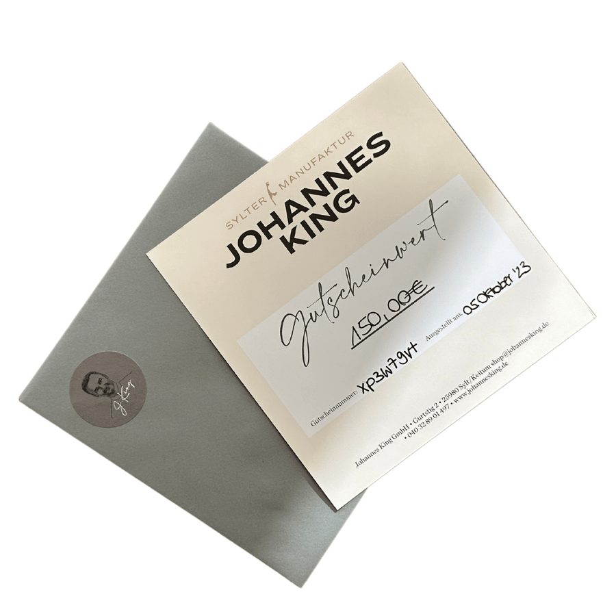 Ein Echtheitszertifikat für einen Johannes King Geschenkgutschein – per Post, begleitet von einem grauen Umschlag mit eingeprägtem Firmenlogo.