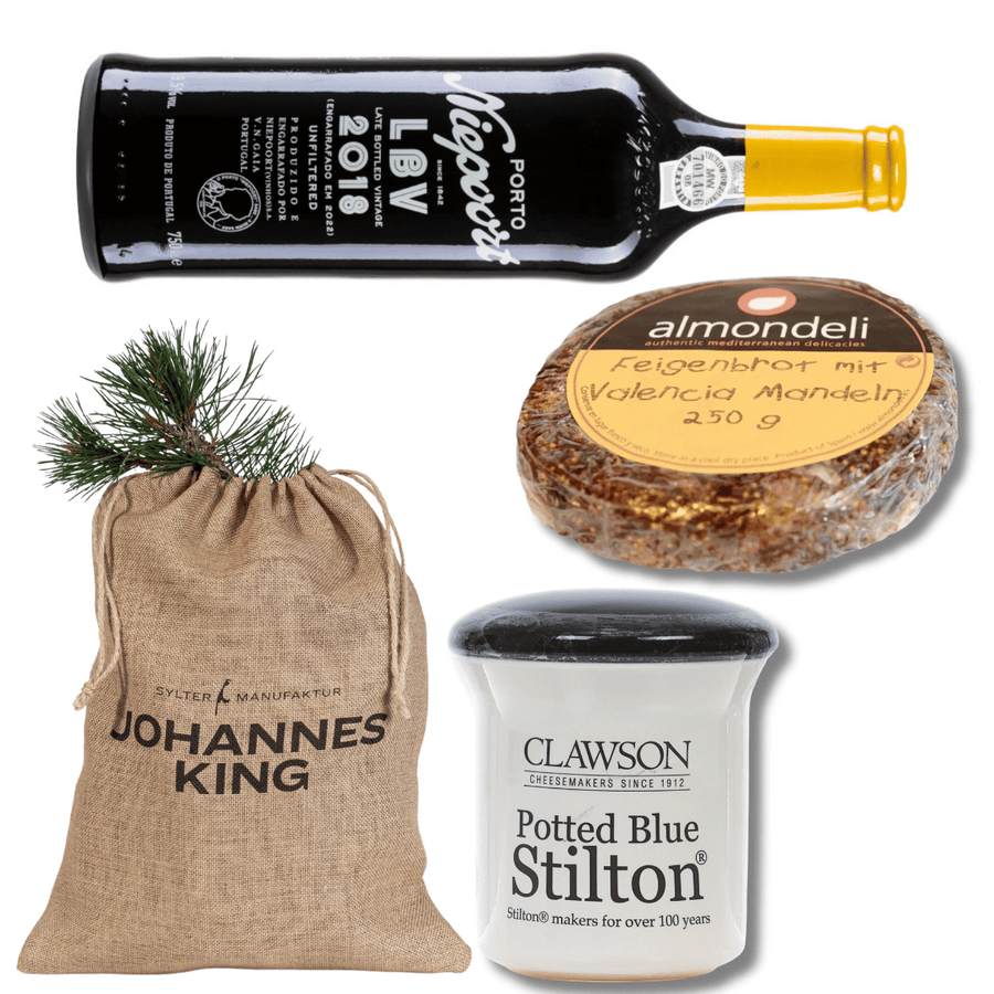 Ein Arrangement mit Gourmet-Lebensmitteln, darunter eine Flasche Sylter Manufaktur Niepoort LBV 2018, Mandelstollen in einer runden Verpackung, eingemachter Stilton-Käse und ein Beutel mit der Aufschrift „Kleines Portwein Geschenk“.