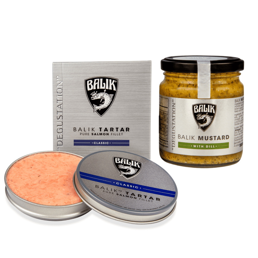 Dieses Bild zeigt eine Reihe von Gourmet-Lebensmitteln von Caviar House Prunier, darunter ein Glas Caviar House Prunier Tatar Classic in einer silbernen Dose, norwegischer Lachs „classic“ und ein Glas Senf-Dill-Sauce.