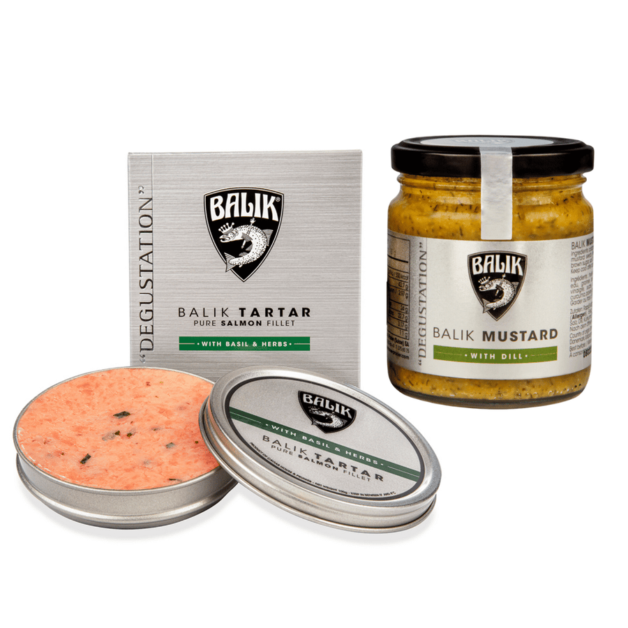 Ein Balik Genießer-Set: Tatar Basilikum & Kräuter & Senf-Dill-Sauce neben einem Glas Balik Senf-Dill-Sauce, beide Produkte sind mit dem Firmen-Branding und der Verpackung von Caviar House Prunier gestaltet.